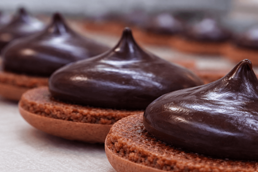Geöffneter Schokolade Macaron mit glänzender dunkler Schokoladencreme – handgemacht von eve chocolatière tübingen